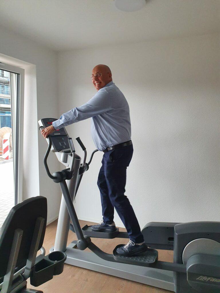 Ein älterer Mann trainiert auf einem Crosstrainer.